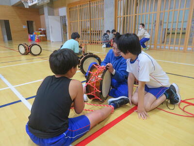 協力して、太鼓を締め直しています