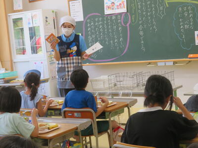 先生から防災給食についての話を聞く３年生。